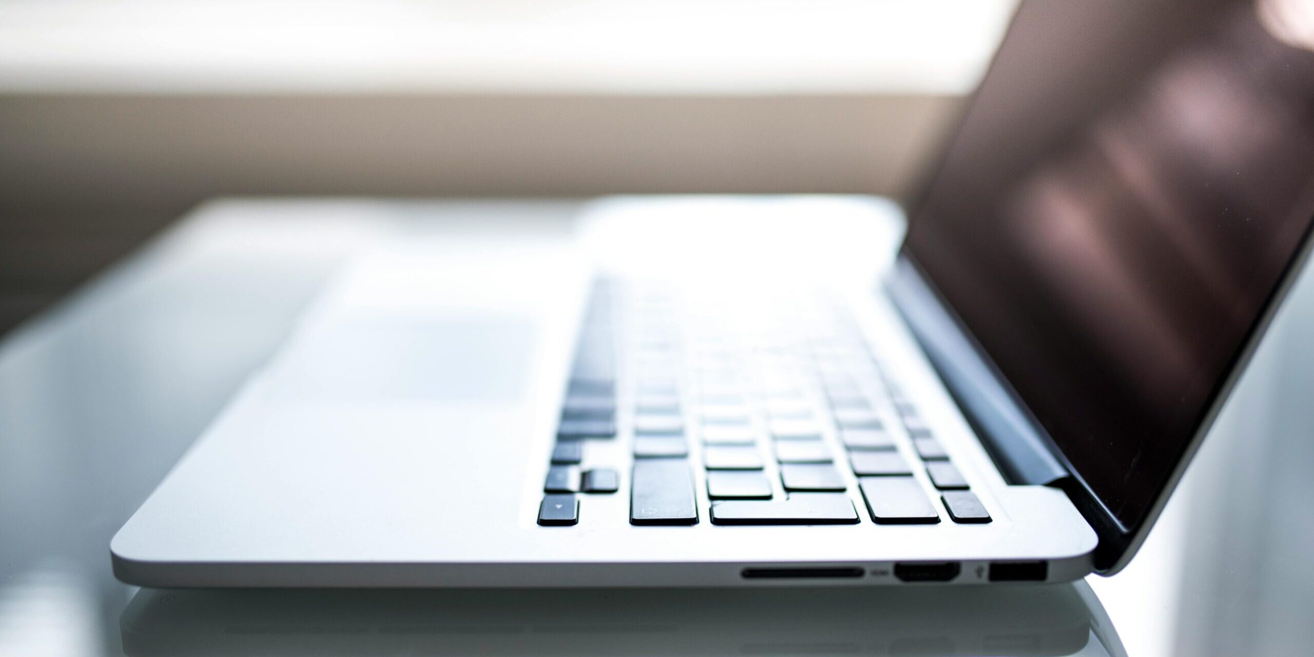 What-Your-Small-Business-MUST-Know-About-Data-Regulations-in-2025-scaled.jpg Free Elegant side view of a laptop on a glossy table with natural lighting indoors. Stock Photo