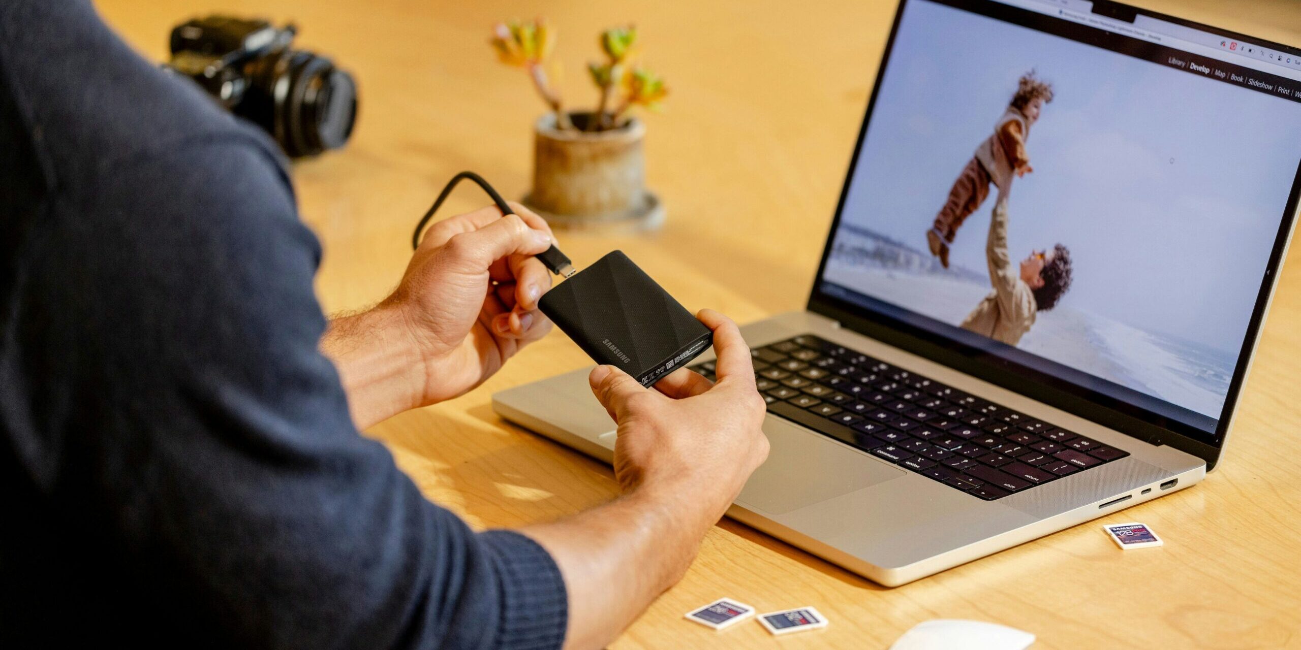 A man sitting at a table with a laptop and cell phone