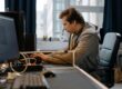 Free A concentrated professional working at a computer in a modern office setting. Stock Photo